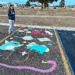 Parking spot painted with frogs and emojis