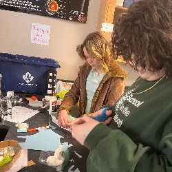 Two students work at a lab table in their science class; they are making 3D representations of cells.