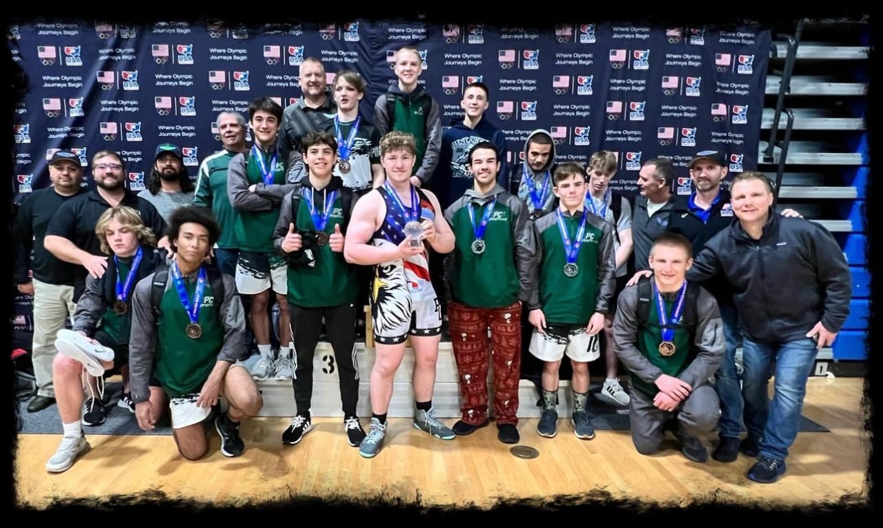 Wrestling team posing with medals