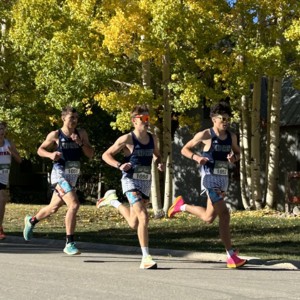 Boys running in front of trees