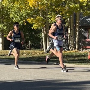 Boys racing in front of trees