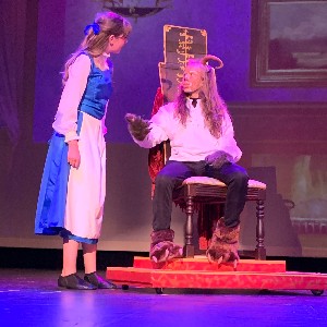 Belle and the Beast talking on stage.