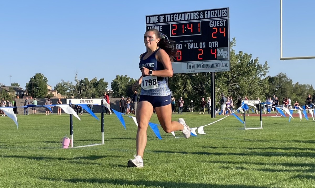 Kaylee Castellini crossing the finish line at the Widefield Invitational. 