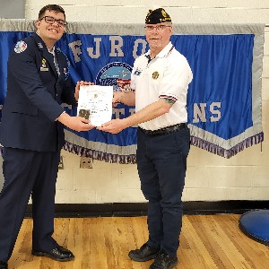 Two people holding an awards certificate