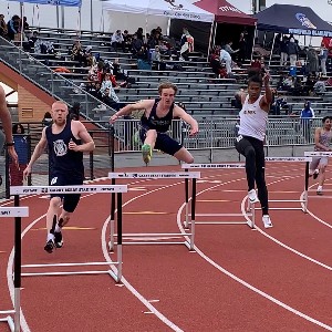 Male athletes competing in the hurdles