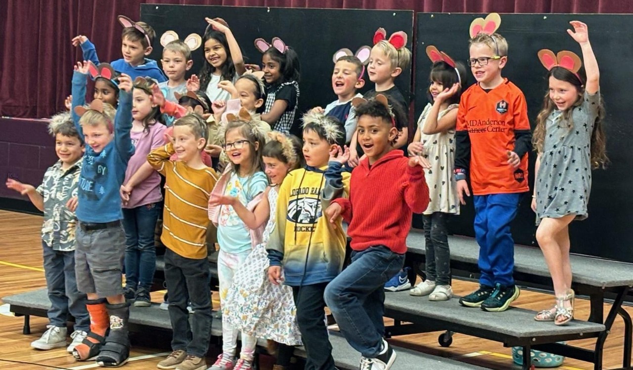 Kindergarten students in a performance wearing mouse ears