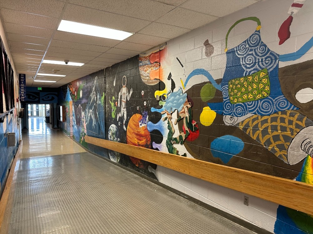 A long wall inside AAHS with art painted by students.