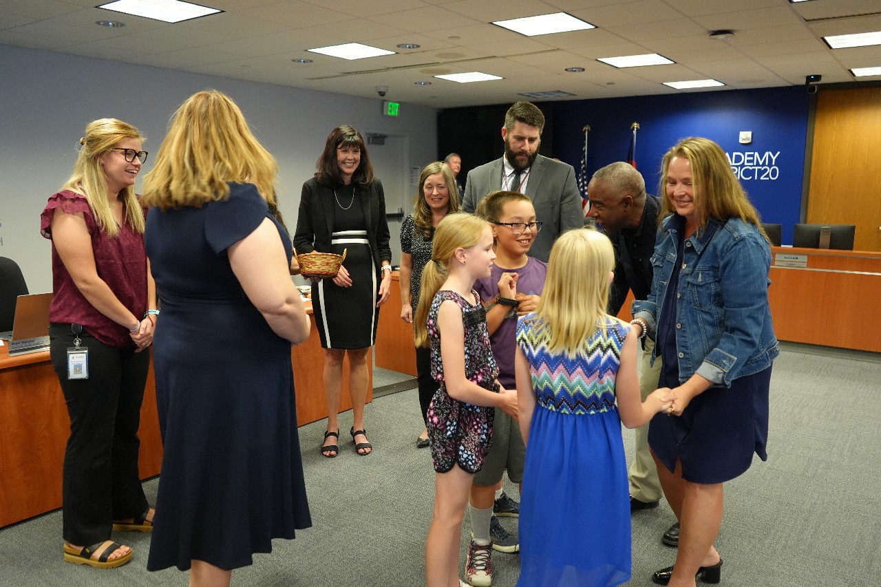 Board members give student a gift for attending Board of Education meeting