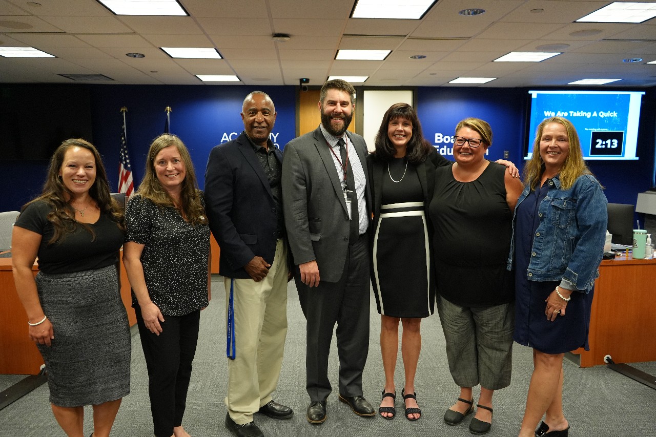 Board of Education members, D20 Superintendent and Emily Heinrich smile for a photo