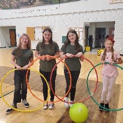 Four Mountain Ridge Middle School students standing in the gym, holding hula hoops