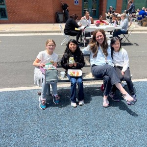 Teacher and students enjoy lunch on a bench