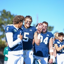 Players being silly and holding up a hand gesture of a claw on the sidelines