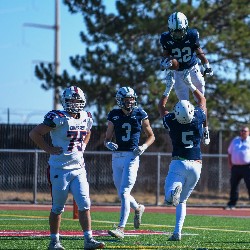 Player #5 lifts player #22 in the air in celebration of a touchdown