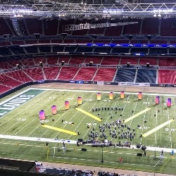 The PCHS marching band performs on a football field.