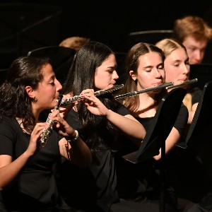 Four girls playing flute at a concert