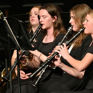 Three girls playing clarinet at a concert