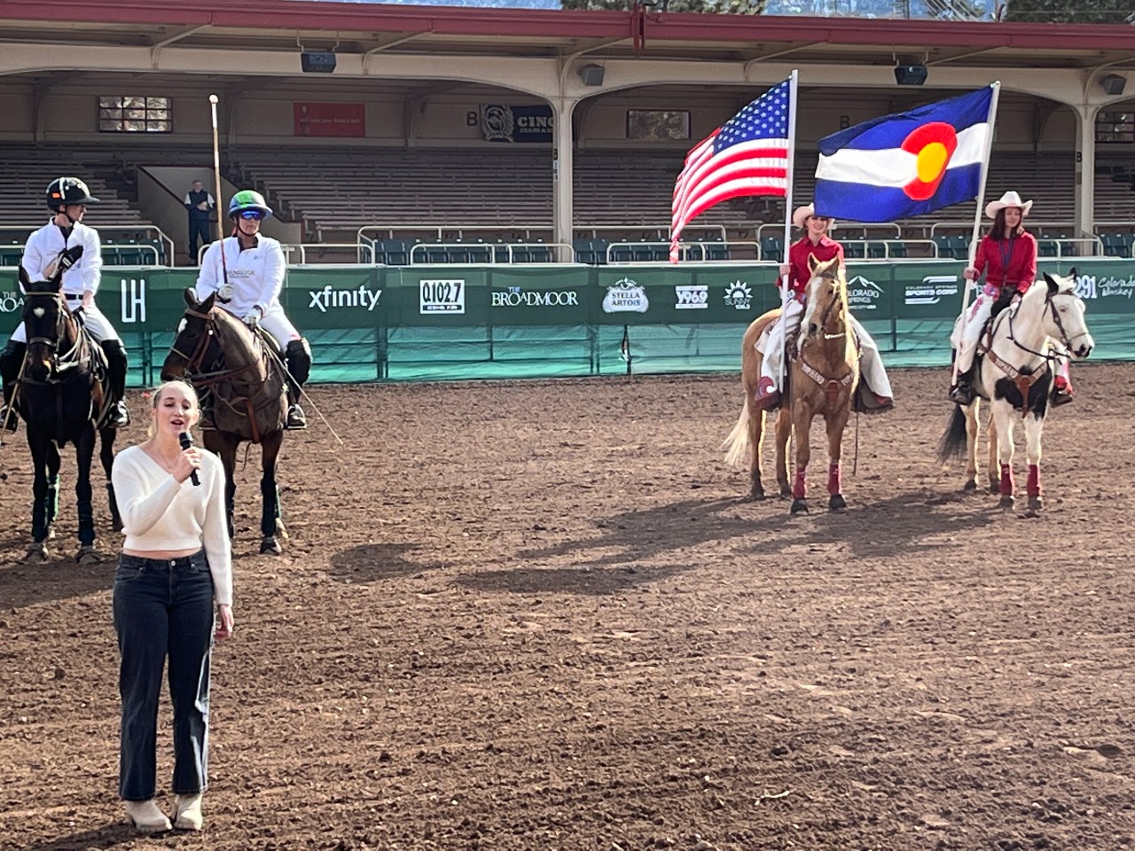 Polo players listen as Liv sings the National Anthem.