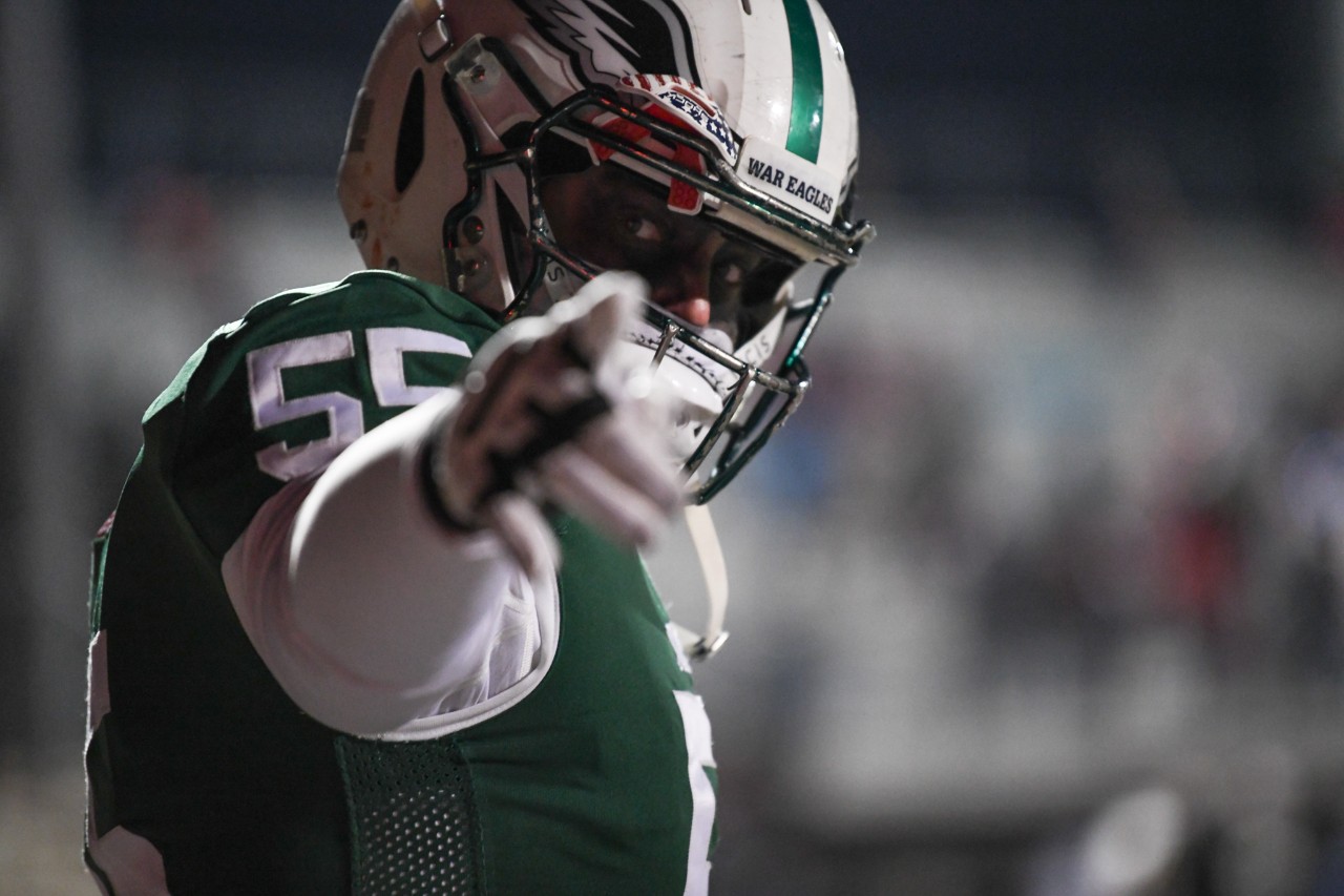 Closeup shot of football player wearing helmet and pointing at the camera