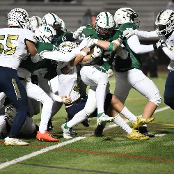 Player tries to run the football down the field and is met by players from Legacy trying to tackle him