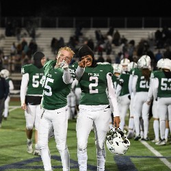 Two football players point at the camera