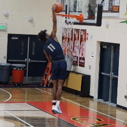 An AAHS basketball player does a slam-dunk.