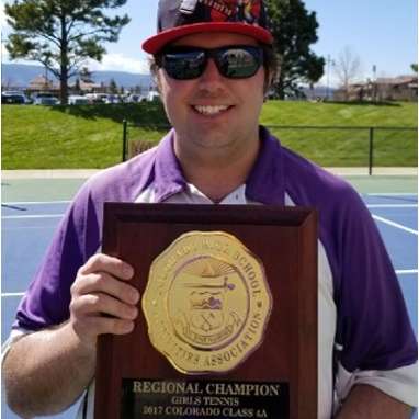 Coach Thirkell holding a regional championship plaque.