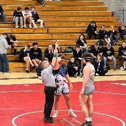 Referee holds Pine Creek wrestler's arm high, indicating he just won his match