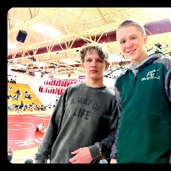 Two wrestlers smile for the camera at the state competition