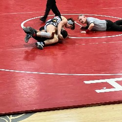 Wrestler pins opponent with referee nearby to make a call for the win