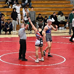 Referee holds Pine Creek wrestler's arm high, indicating he just won