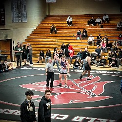 Referee holds Pine Creek wrestler's arm high, indicating he just won his match!