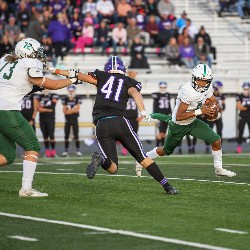 Player who is running with the football tries to avoid approaching member of the opposite team