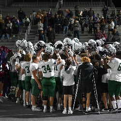 The team holds their helmets in the air in celebration