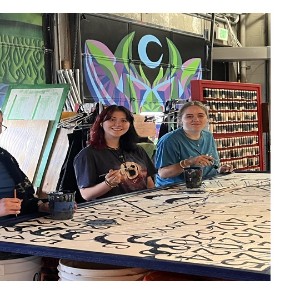 Elise Kretschmer, Natalie Mahaffey and Madison Burden painting a mural