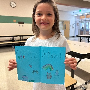 student smiles with a birthday card