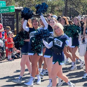 Cheer team members participate in a parade.