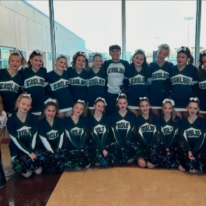 The PCHS Cheer team poses in front of a window.