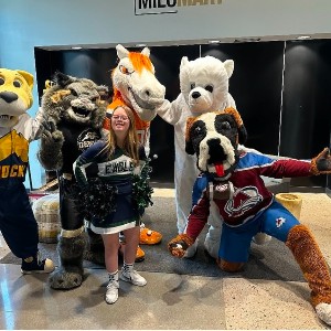 A PCHS Cheer team member poses with mascots from a variety of other athletics teams.