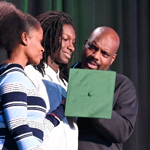 Family contemplates how to get graduation cap on student