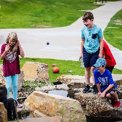 TDVA students participate in club work outside near a pond.