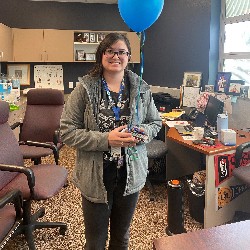 Student poses with balloons in celebration of being names a National Merit Finalist