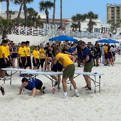 Student crawling under a table for the obstacle course