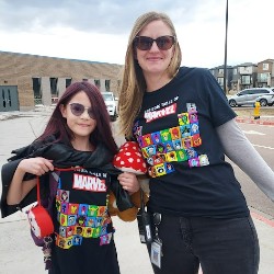 Student and adult wearing matching Marvel shirts