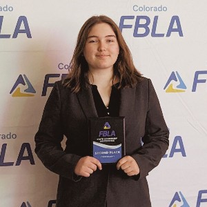 Student with plaque, 2nd place in the state for Cybersecurity