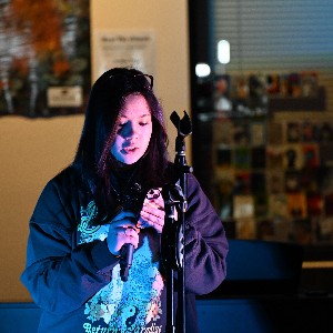 Student performing a poem at Open Mic Night