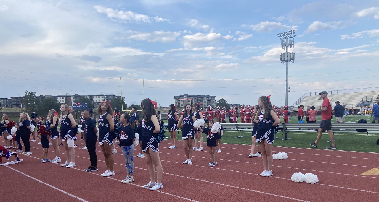 Cheerleaders and campers cheer at the Liberty Football game Friday Evening, September 8, in the D20 stadium.