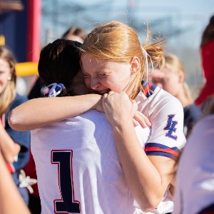 Two Liberty softball players embrace on the field after the seniors' final game.