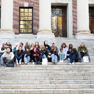 Liberty yearbook students and staff sponsors sit on the steps outside of a museum in Boston during their November conference in the city.