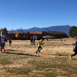 Students running on the activity field behind High Plains Elementary School.