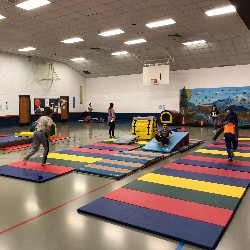 Students exercising on colorful mats in the High Plains Elementary School gym.